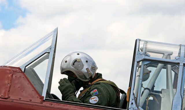 harvard pilot, adjusting oxygen mask, flying suit, cockpit, preparing for takeoff, south african air force museum, aviation