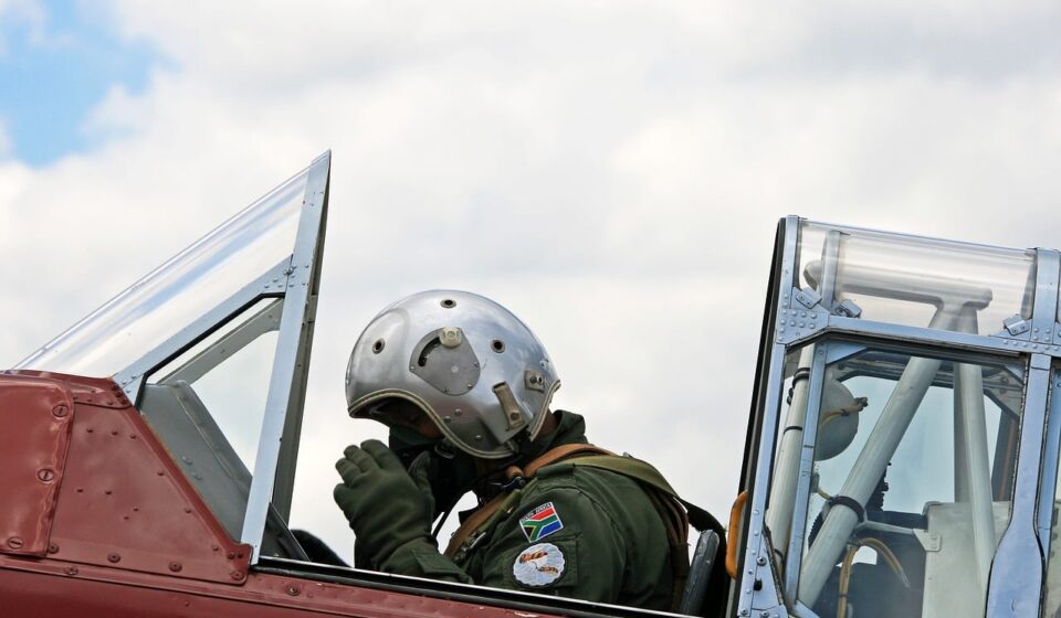 harvard pilot, adjusting oxygen mask, flying suit, cockpit, preparing for takeoff, south african air force museum, aviation